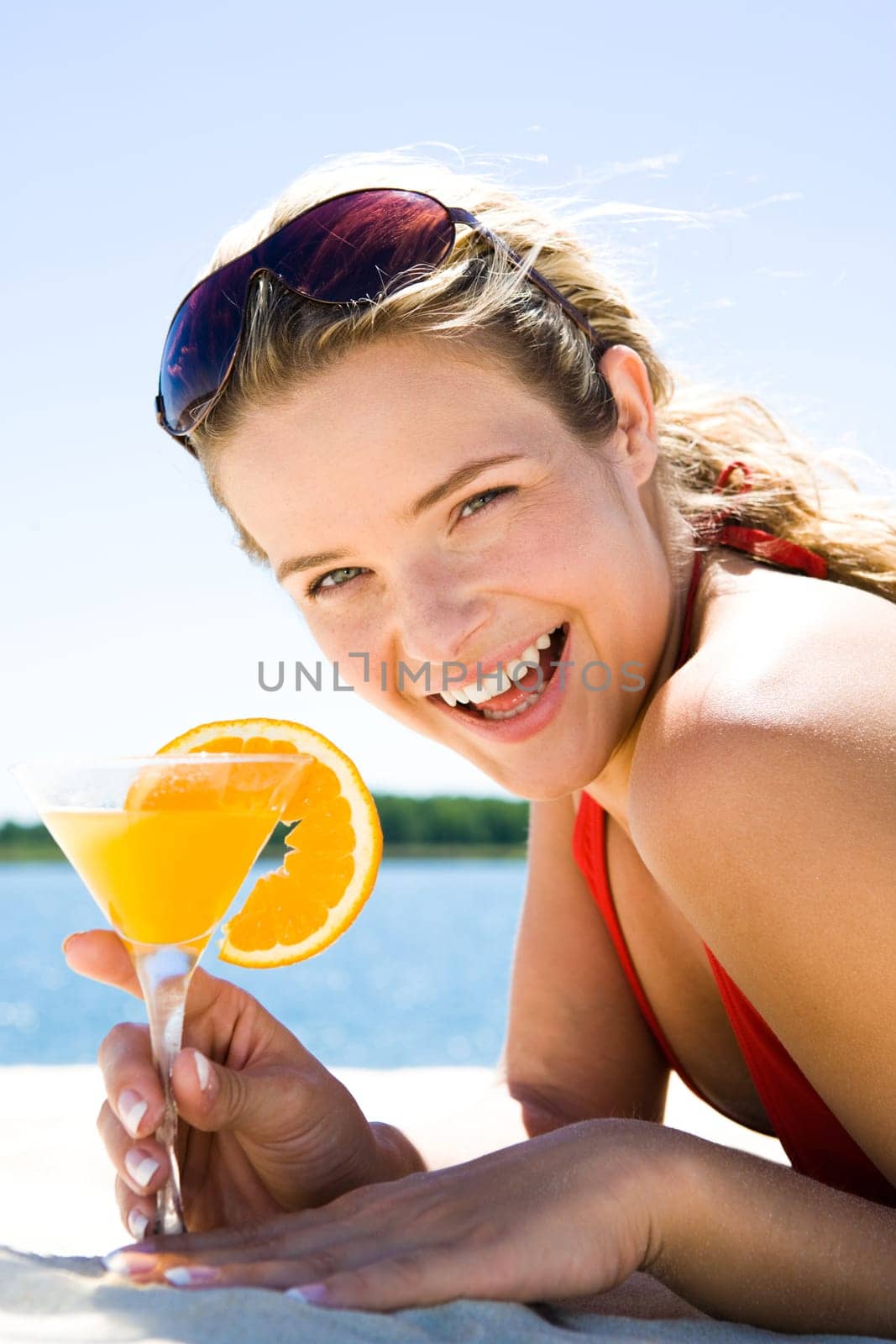 Photo of beautiful woman holding a orange cocktail and laughing