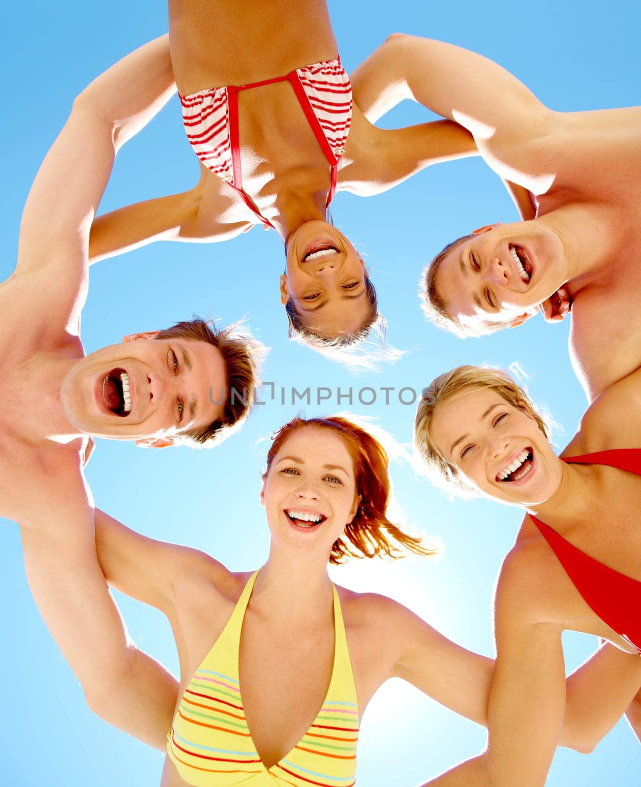 Down view of happy people embracing each other and looking at camera