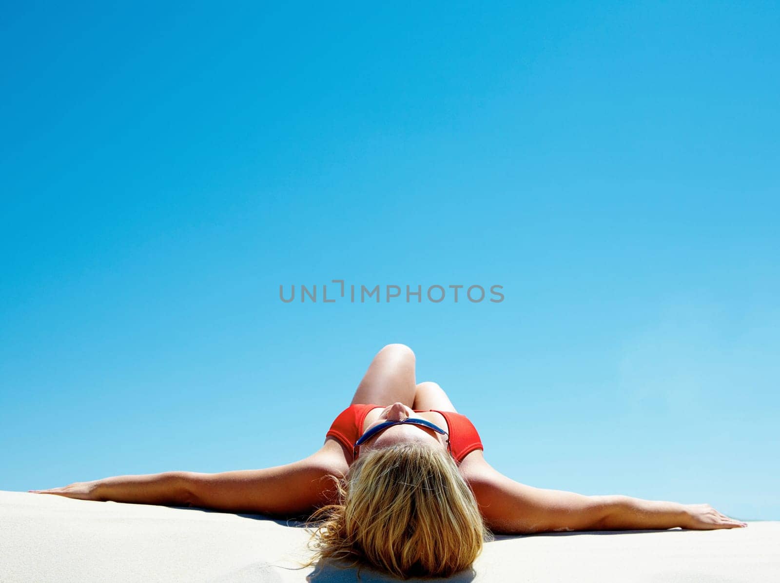 View of beautiful woman lying on the sand getting pleasure