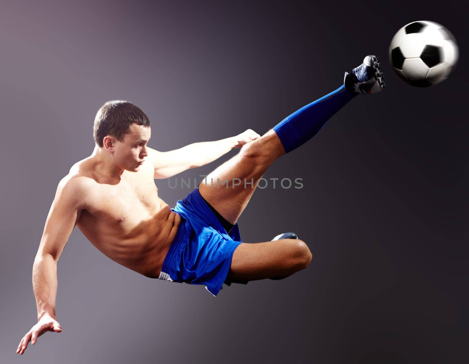 Professional sportsman kicks soccer ball