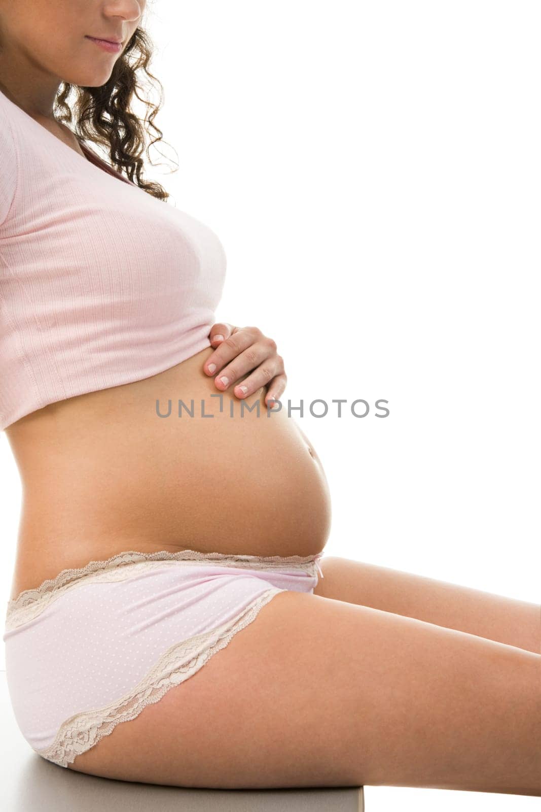 Photo of pretty pregnant woman in tanktop and panties keeping her hand on belly