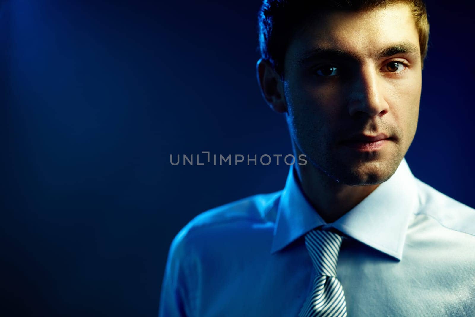 Portrait of attractive male looking at camera in darkness