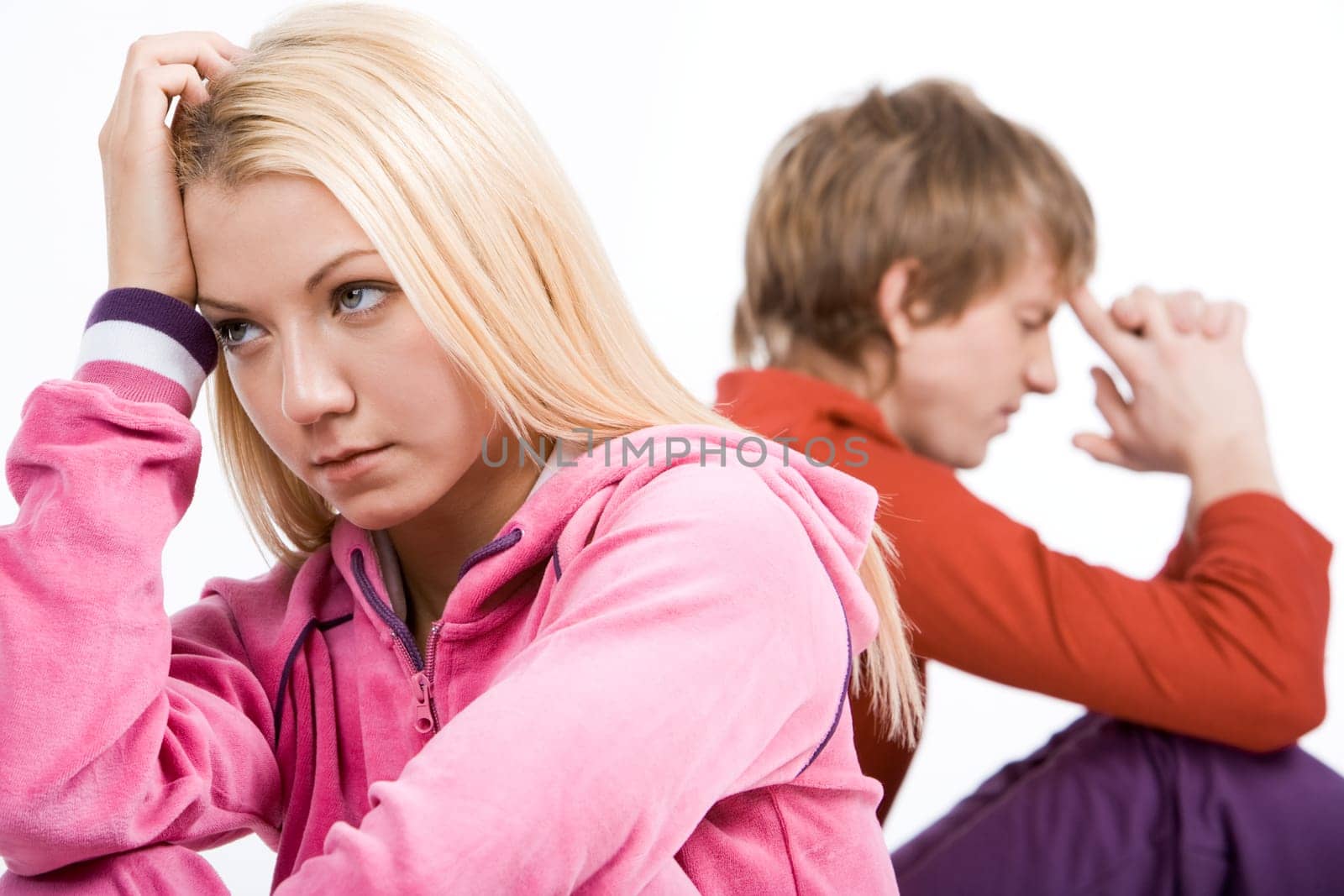 Image of sad girl with confused guy at background after having an argument