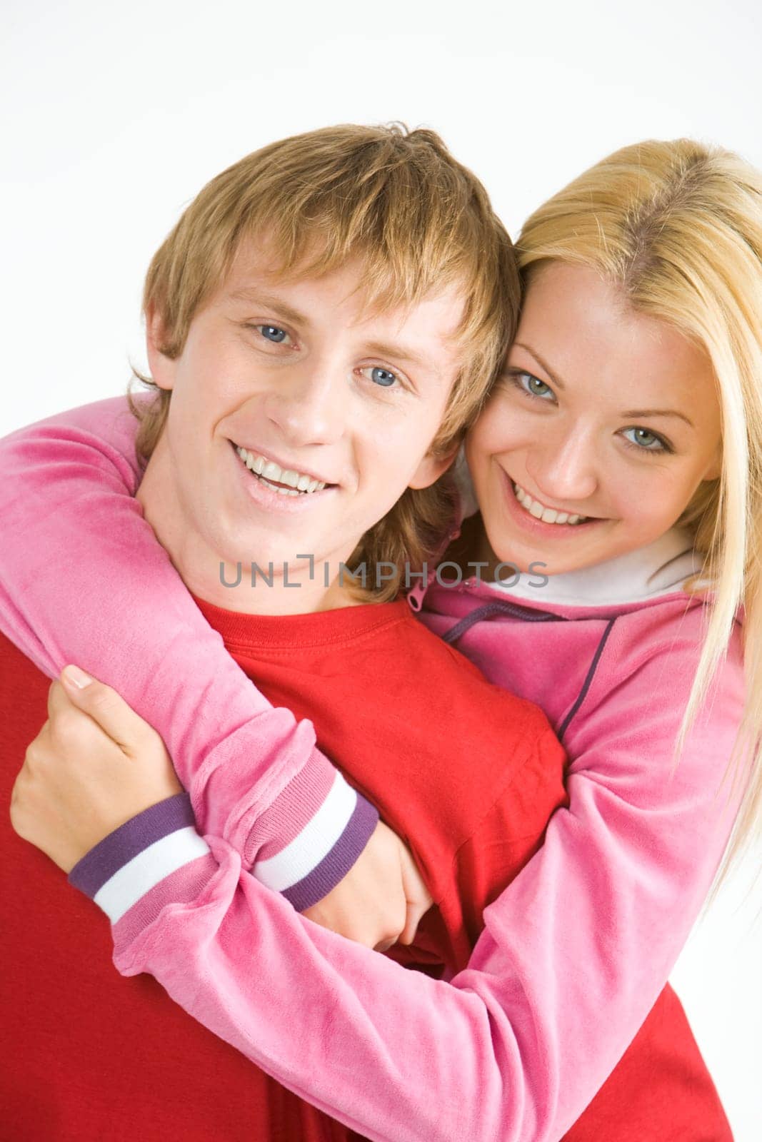 Portrait of happy guy being hugged by his pretty girlfriend