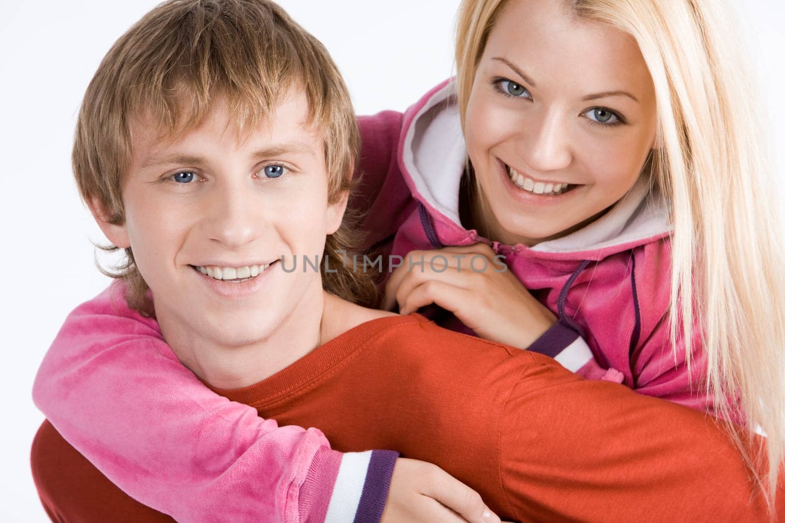 Portrait of happy guy being hugged by his pretty girlfriend