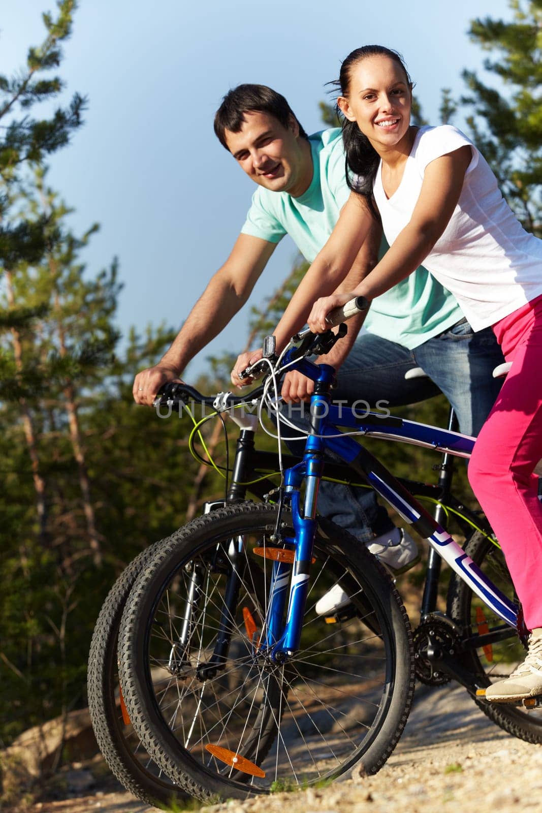 Portrait of a sporting couple on bicycles looking at camera and smiling