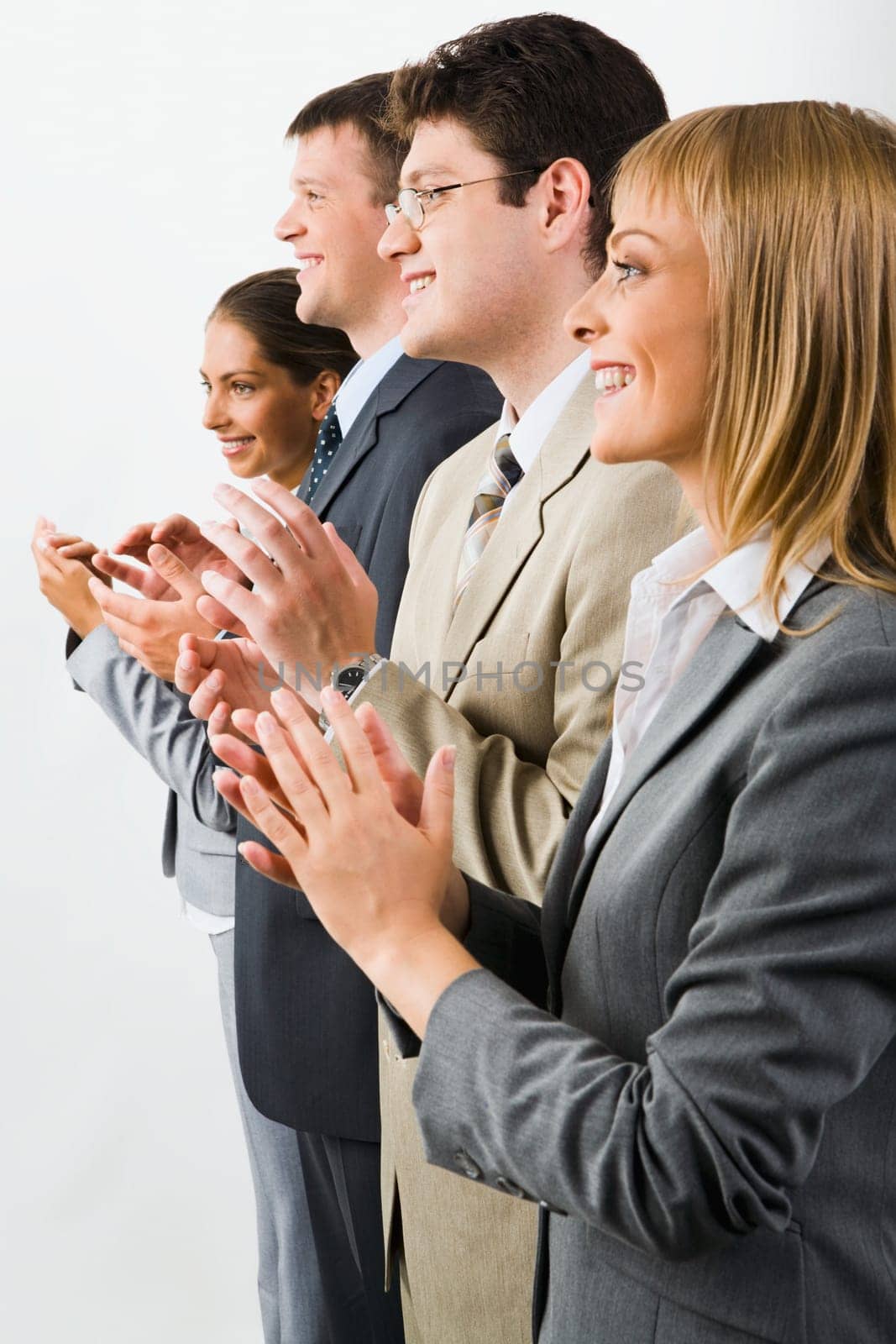 Portrait of business team smiling and applauding on a white background
