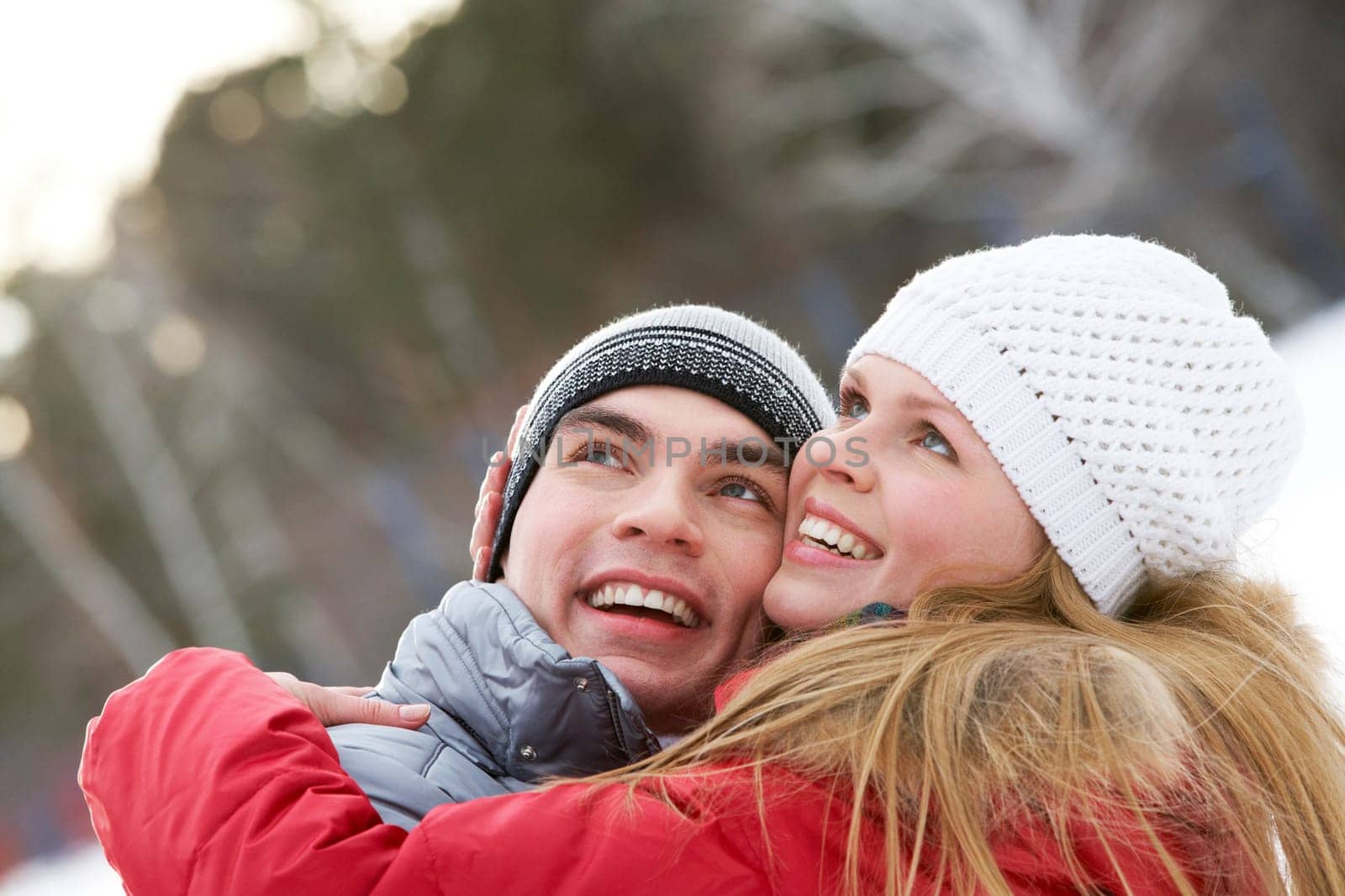 Portrait of happy couple looking upwards while embracing