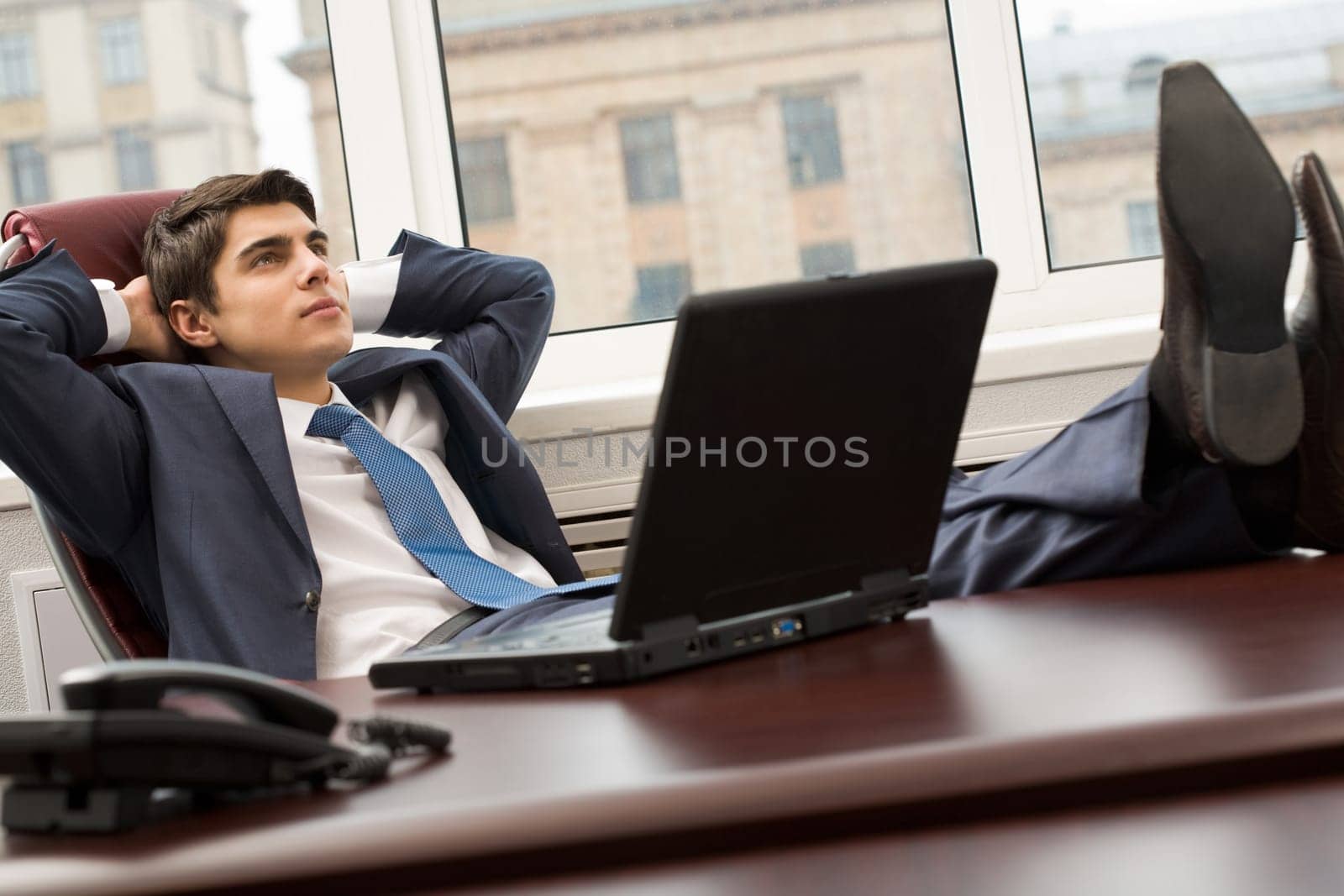 Portrait of smart businessman thinking about something on workplace