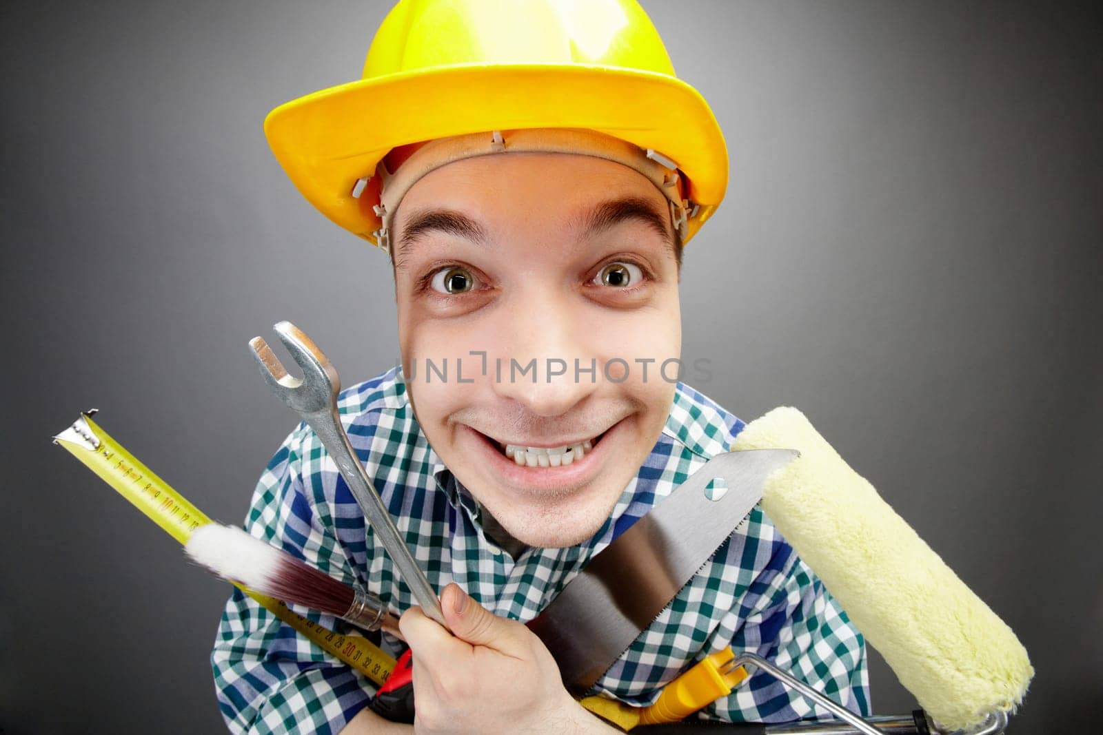 Portrait of happy craftsman with different tools in hands