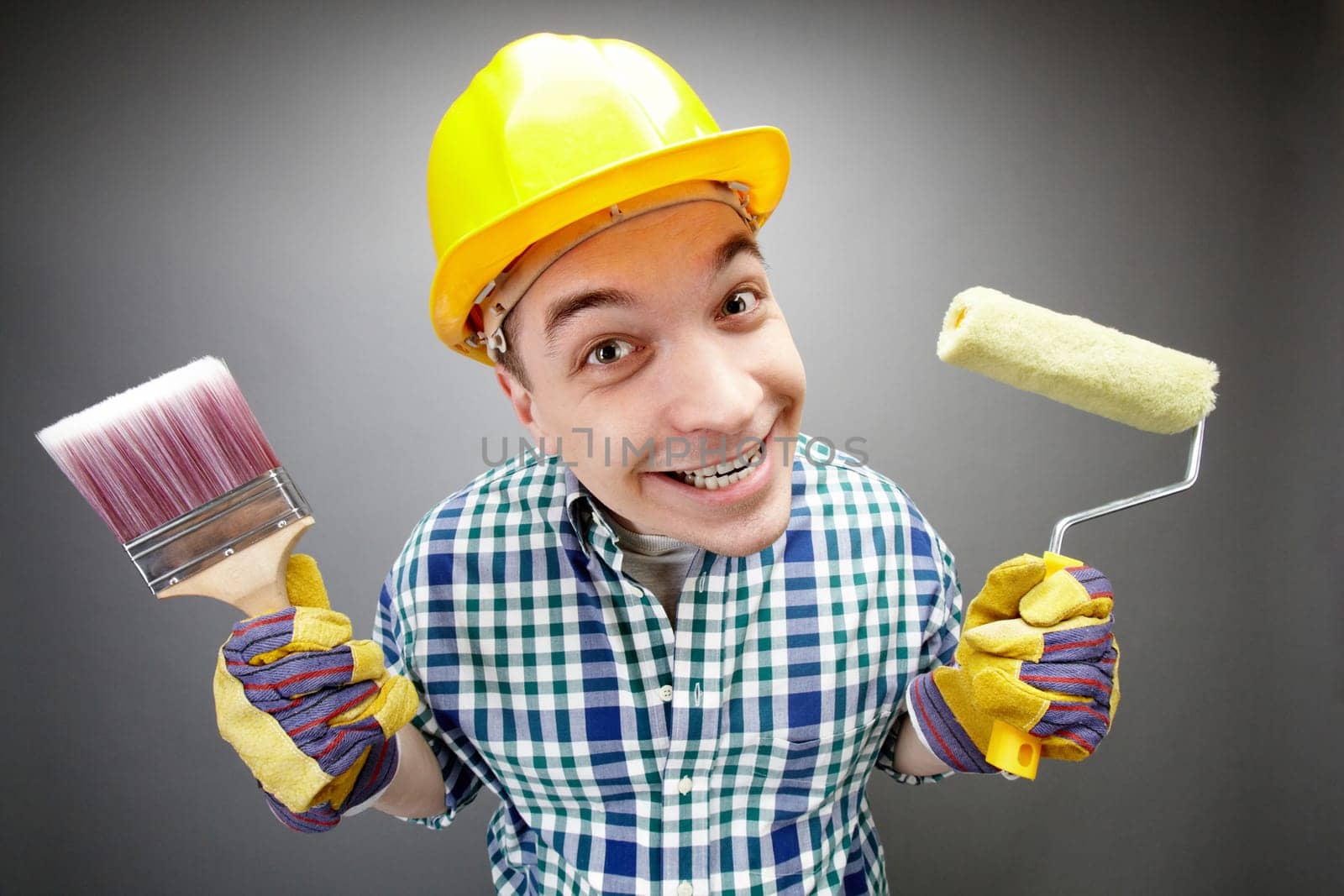 Portrait of smiling painter with paintbrush and roller