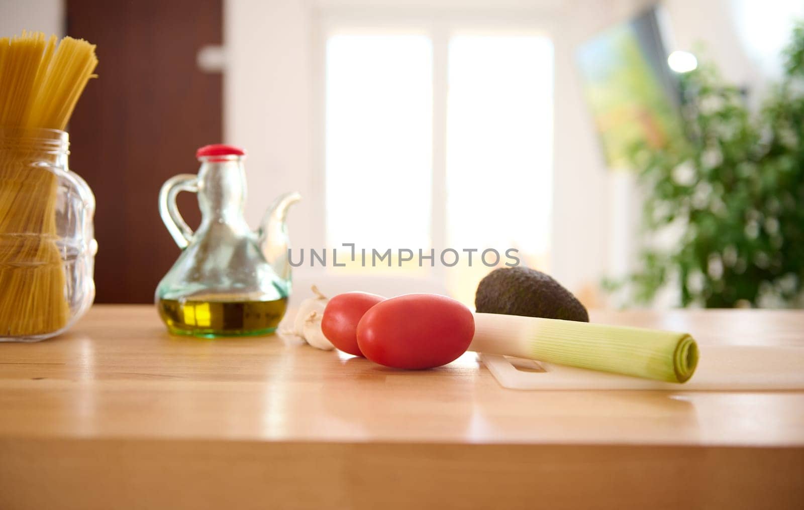 Healthy organic raw vegetables for salad on the table near an oil can with fresh extra virgin oil on the kitchen table. Still life with healthy food ingredients