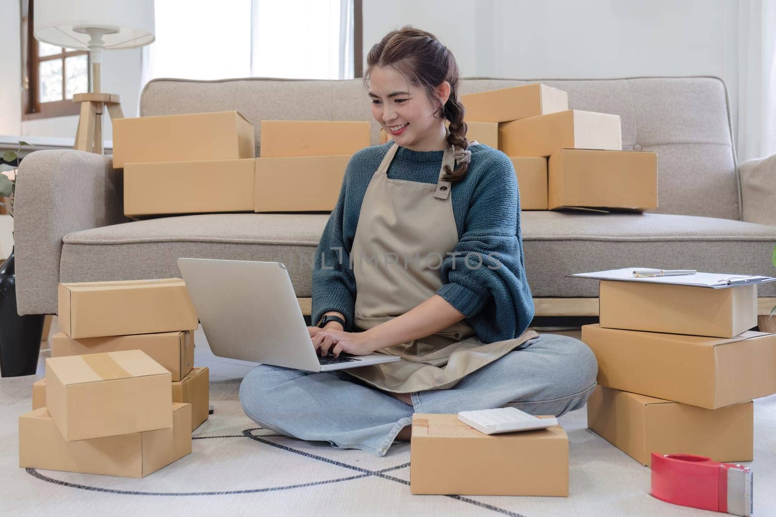 Startup small business entrepreneur SME, asian woman packing cloth in box. Portrait young Asian small business owner home office, online sell marketing delivery, SME e-commerce telemarketing concept.