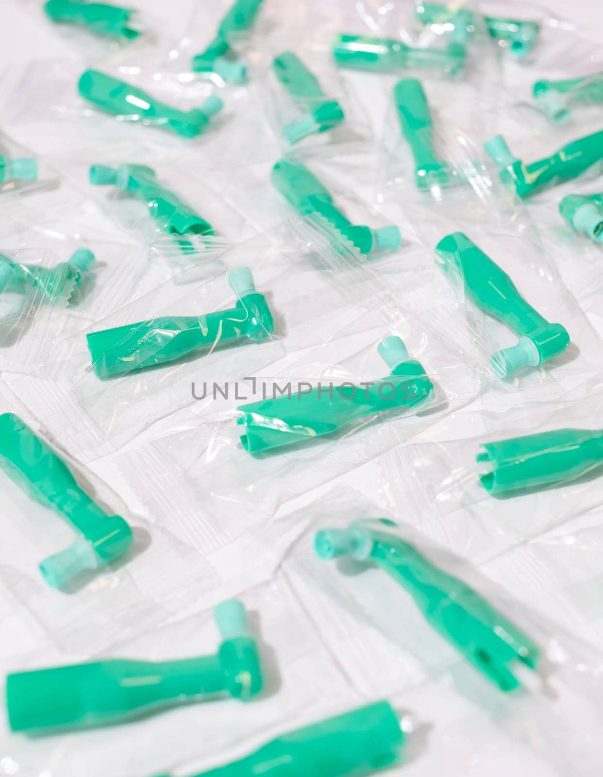 Green Disposable Prophy Angles with Brush, Ergonomic Shape on White Background. Dentistry, Orthodontic Product. Vertical Plane. Oral Hygiene. High quality photo