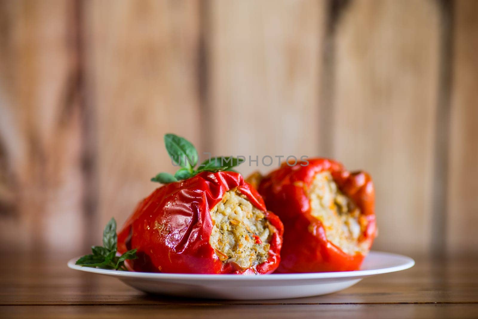 stewed in gravy stuffed peppers in a plate on a wooden table