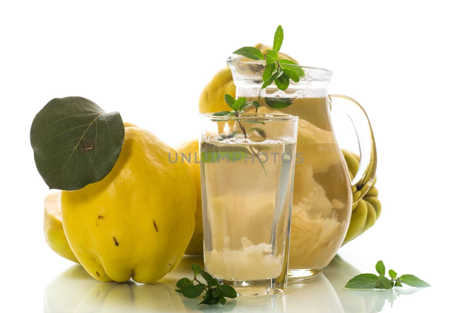 Prepared compote from ripe natural autumn quince, in a glass glass and decanter isolated on a white background.