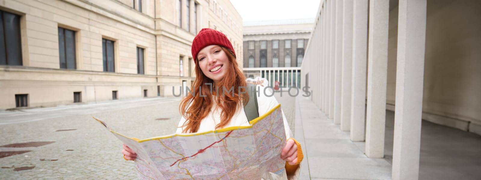 Redhead girl, tourist explores city, looks at paper map to find way for historical landmarks, woman on her trip around euope searches for sightseeing by Benzoix