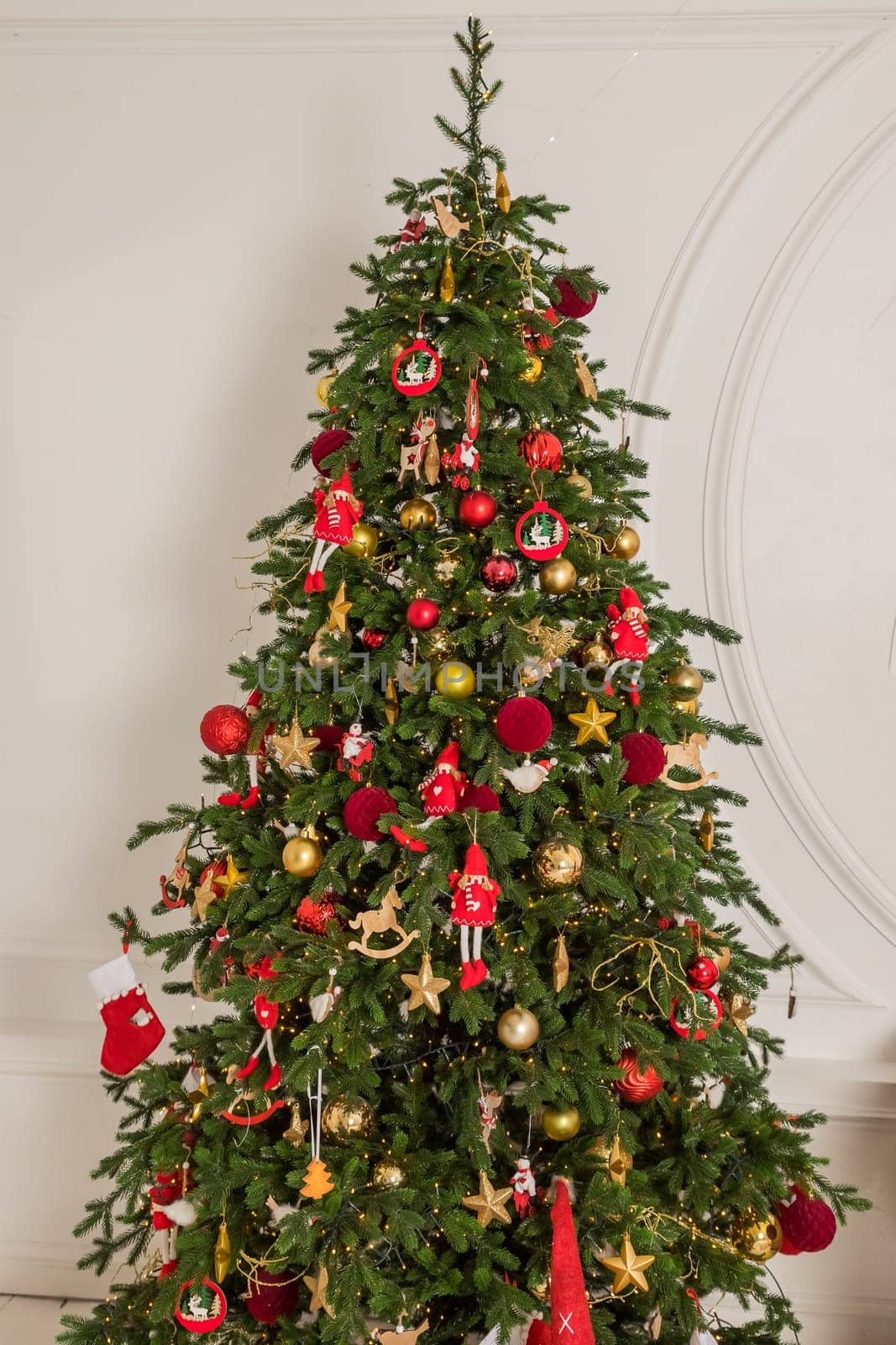 Big christmas tree decorated with beautiful red baubles at home. Copy space.