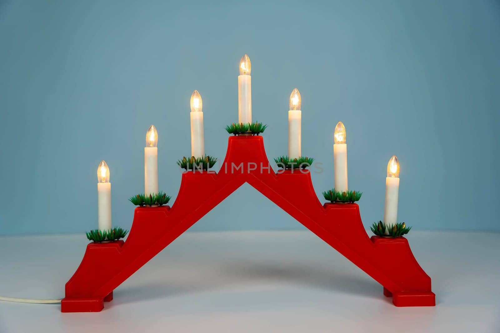 Traditional Christmas candle holder with seven candles on a blue background by audiznam2609