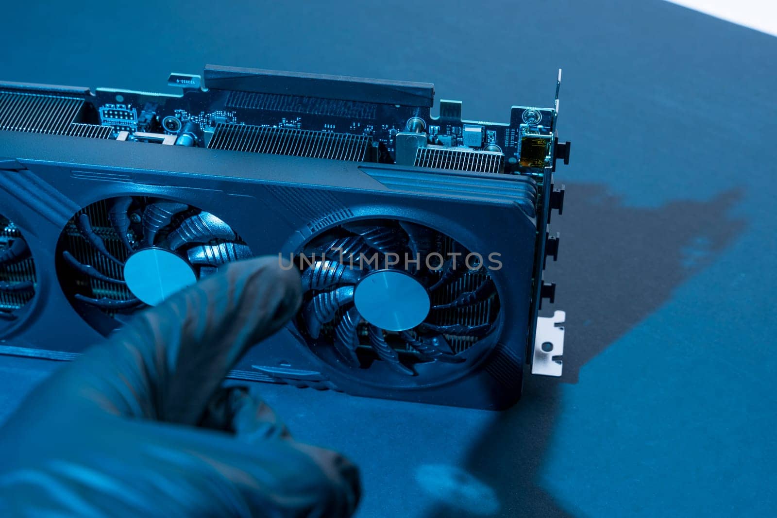 hand of a computer technician holds a modern powerful video game card by audiznam2609