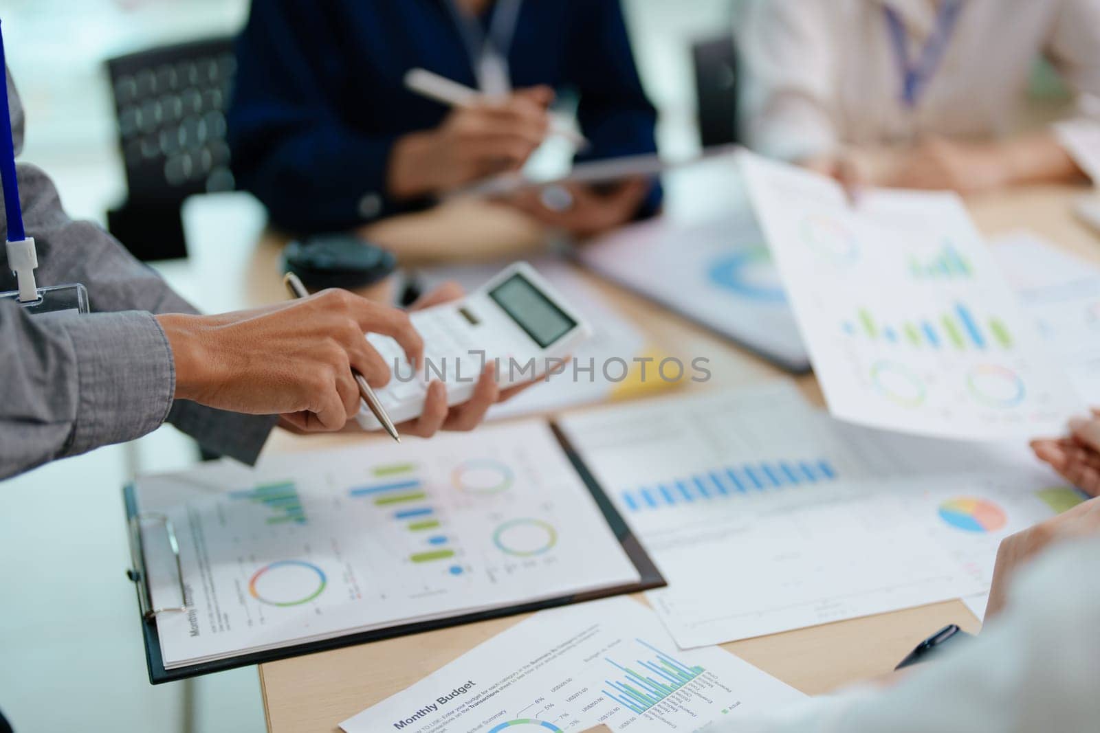 Two business people meeting to talking or discuss marketing work in workplace using paperwork, calculator, computer to work by Manastrong