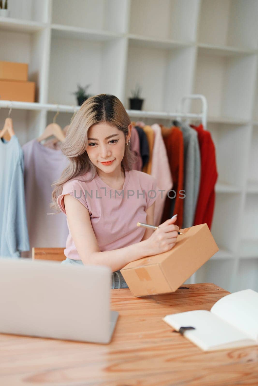 Asian female business owner handles delivery of orders to customers by Manastrong