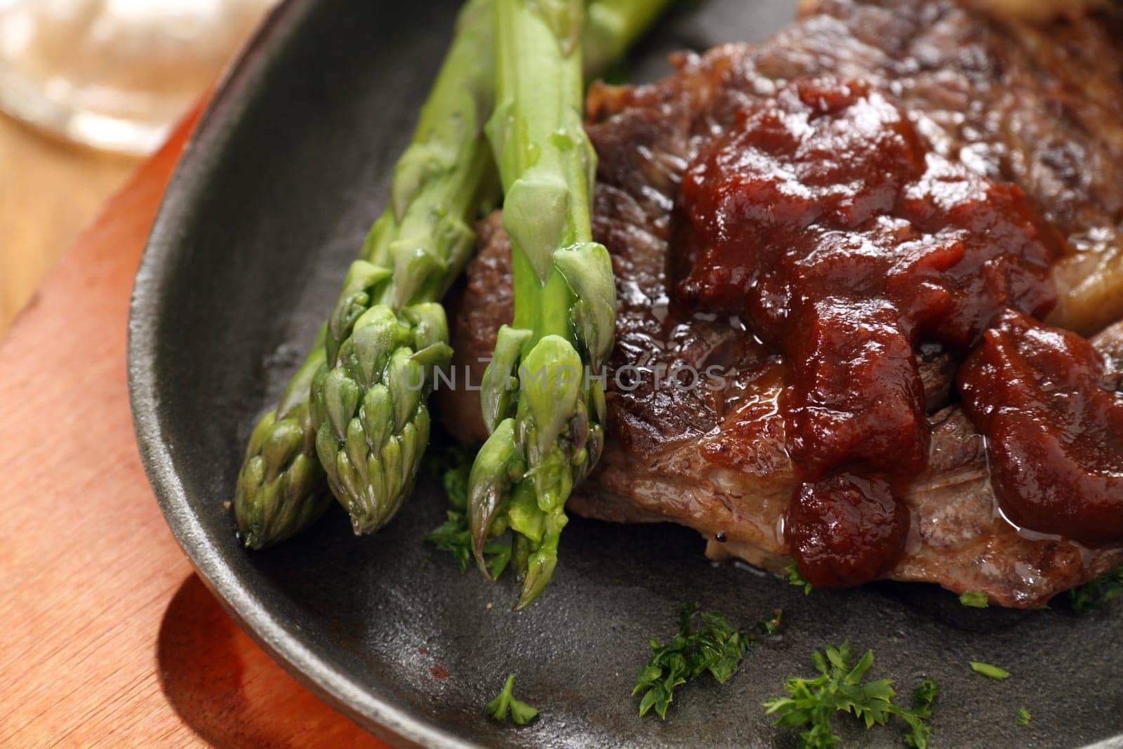 Fresh cooked asparagus with beef steak and ketchup.