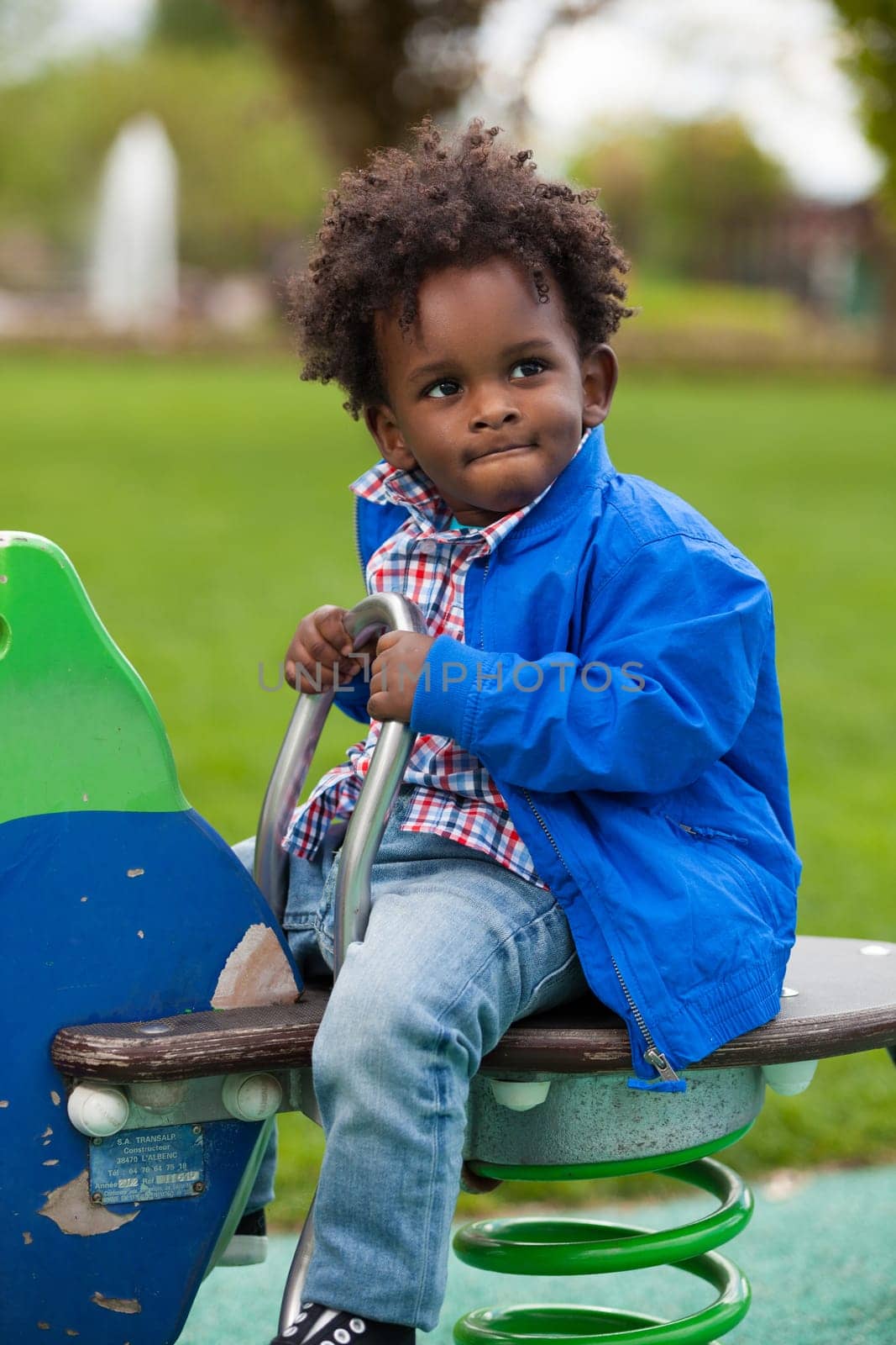 Outdoor portrait of a cute  black baby boy playing at playground