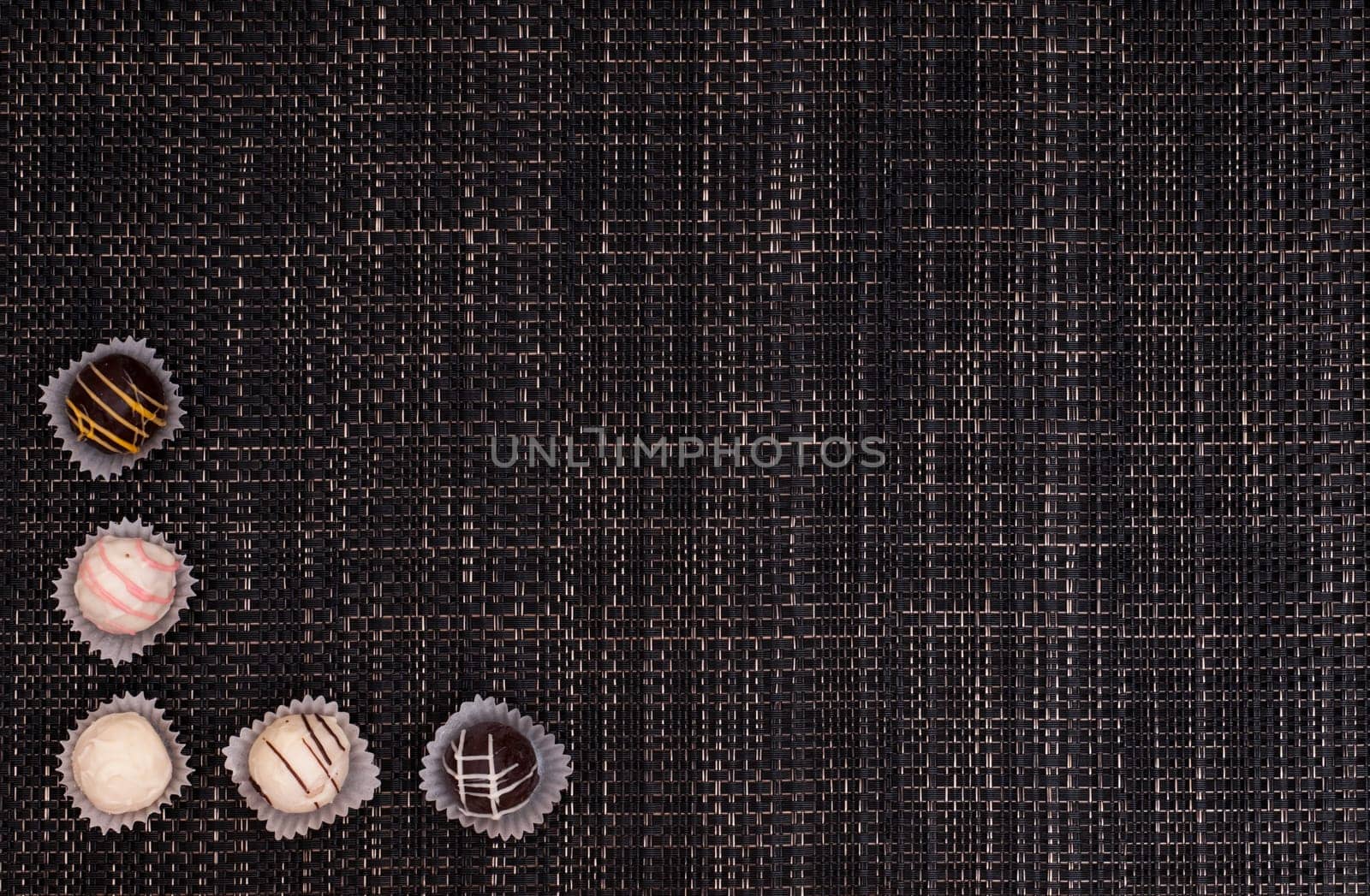 Truffle chocolates made of chocolate on a dark braided fabric