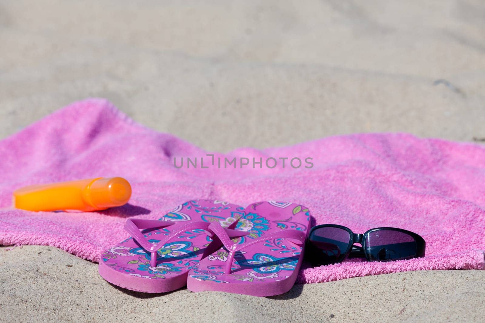 Slippers on the towel on the sandy beach