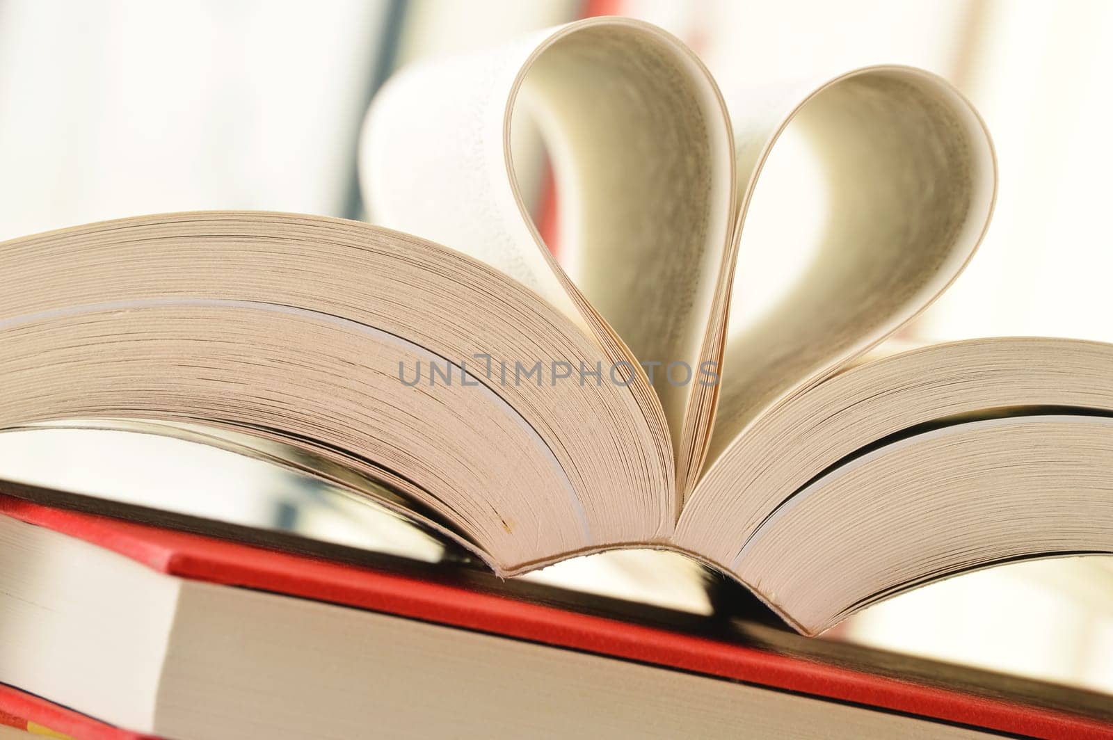Composition with stack of books and pages formed in a shape of heart