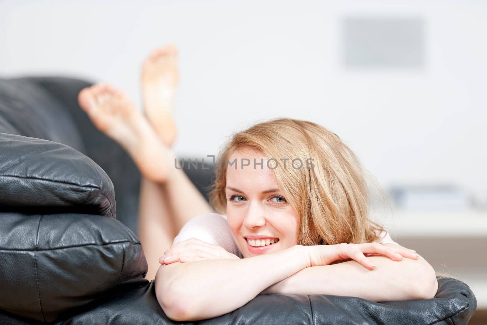 Young woman lying on sofa at home