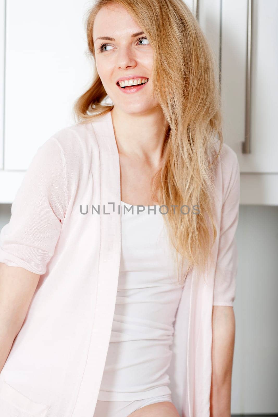 TYoung woman in kitchen in white underwear