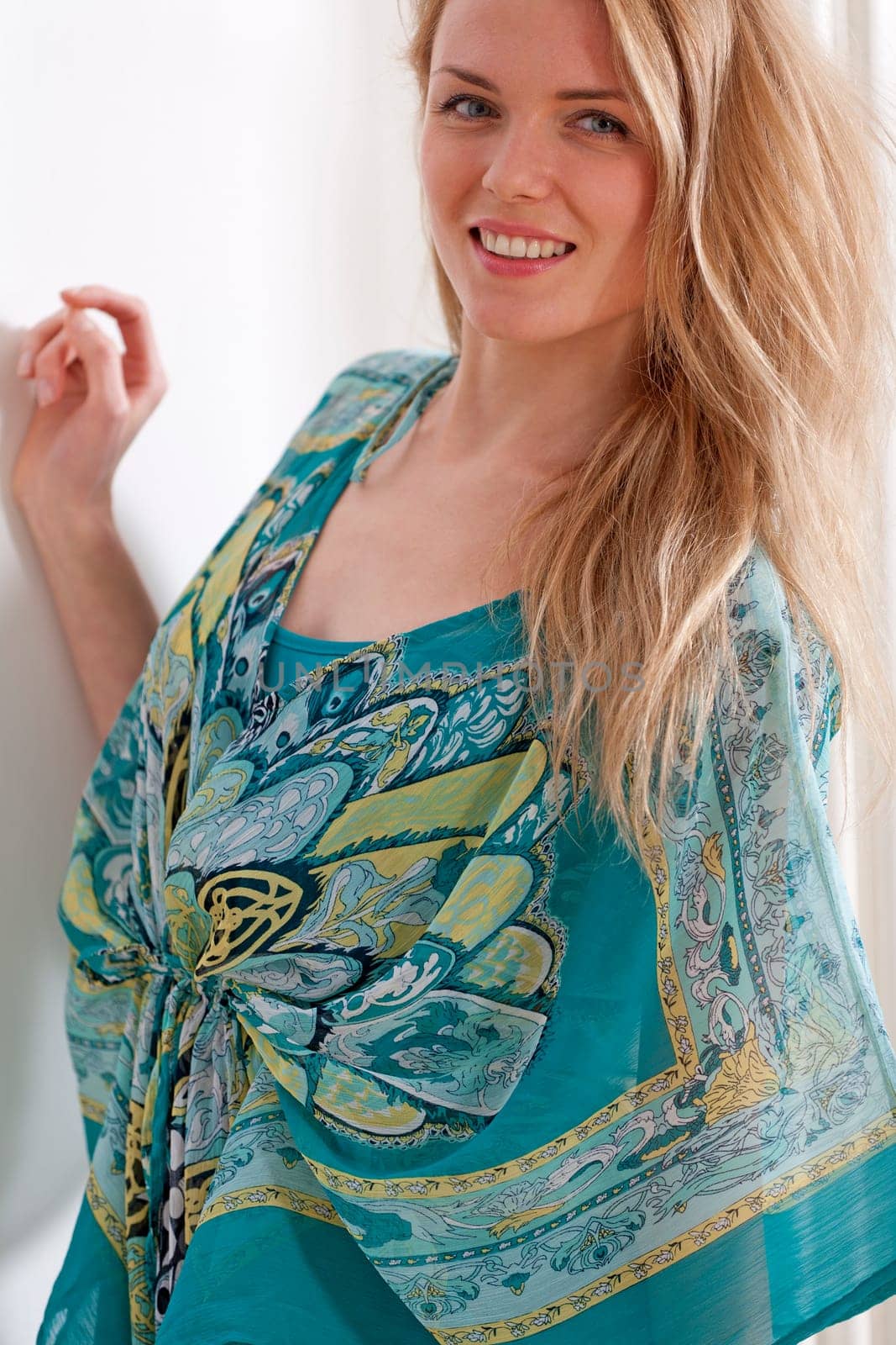 Young woman at home in summer dress against a white wall