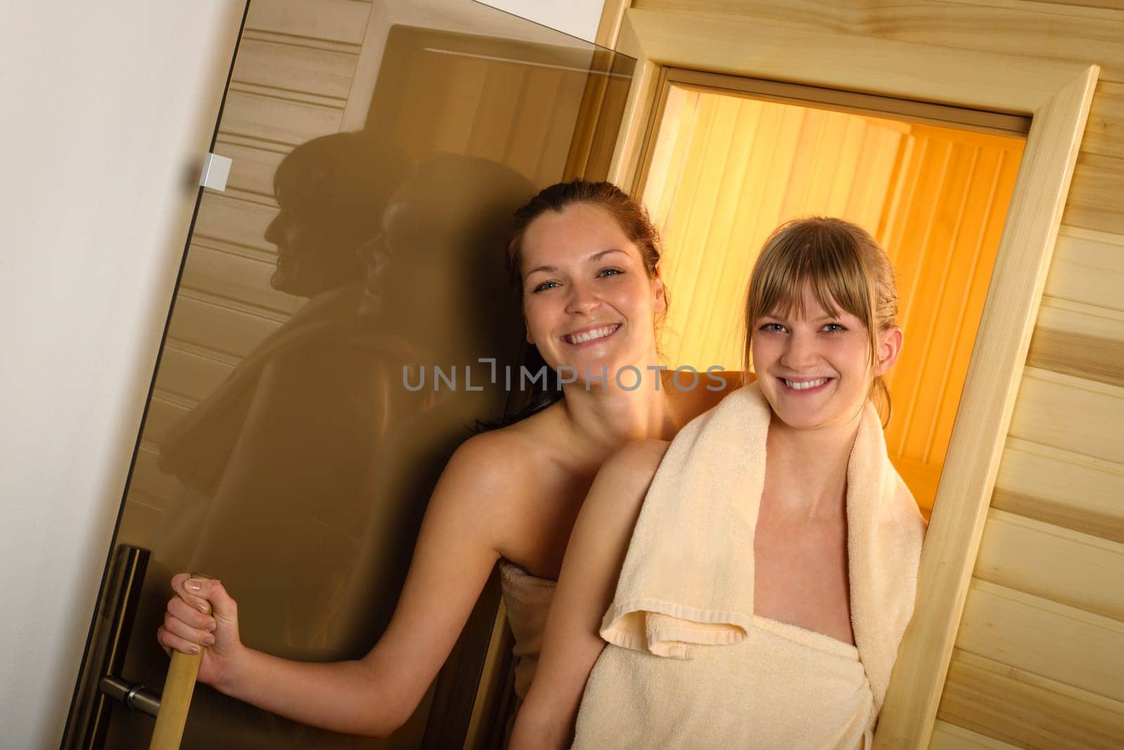 Happy women getting out of sauna at spa center
