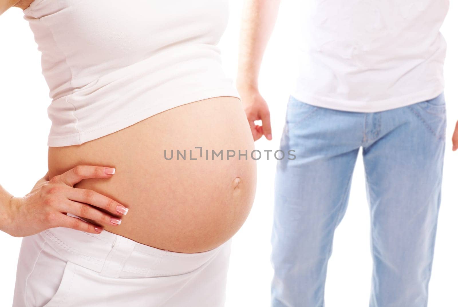 Image of pregnant woman showing her belly with husband on background