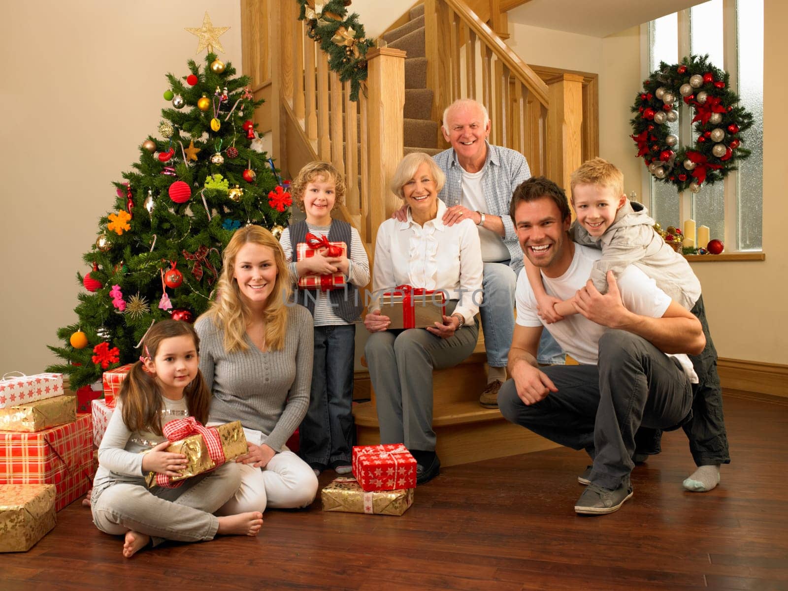 Family with gifts in front of Christmas tree