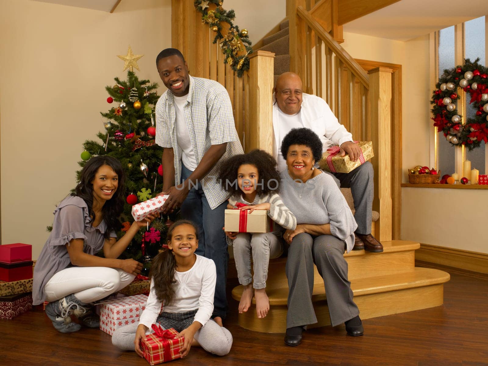 Mixed race family with Christmas tree and gifts
