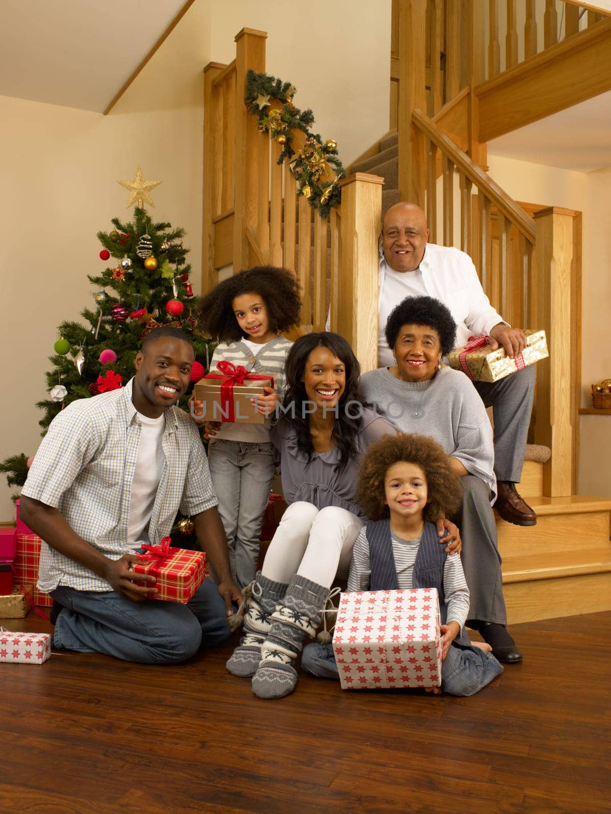Mixed race family with Christmas tree and gifts