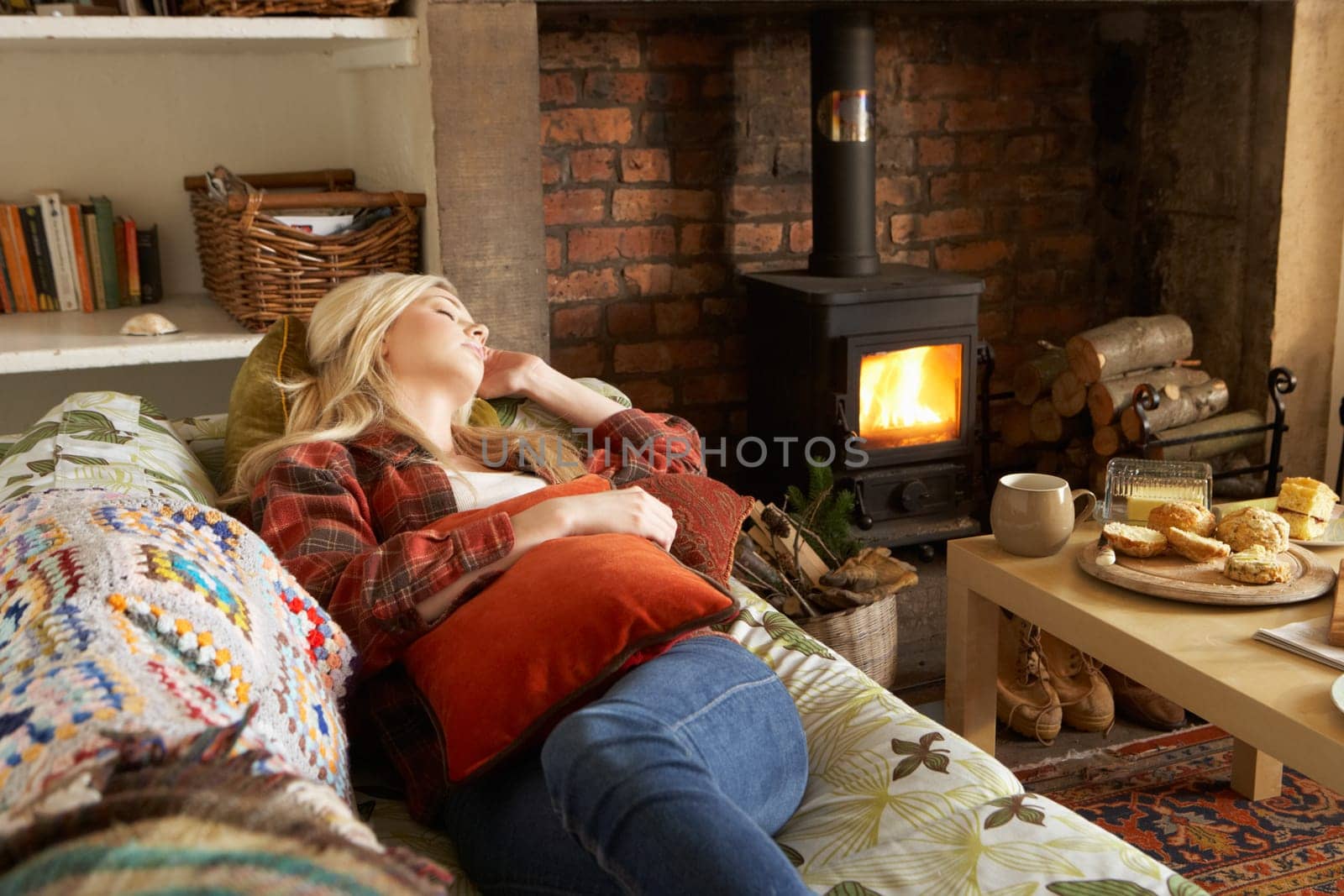 Young woman relaxing by fire