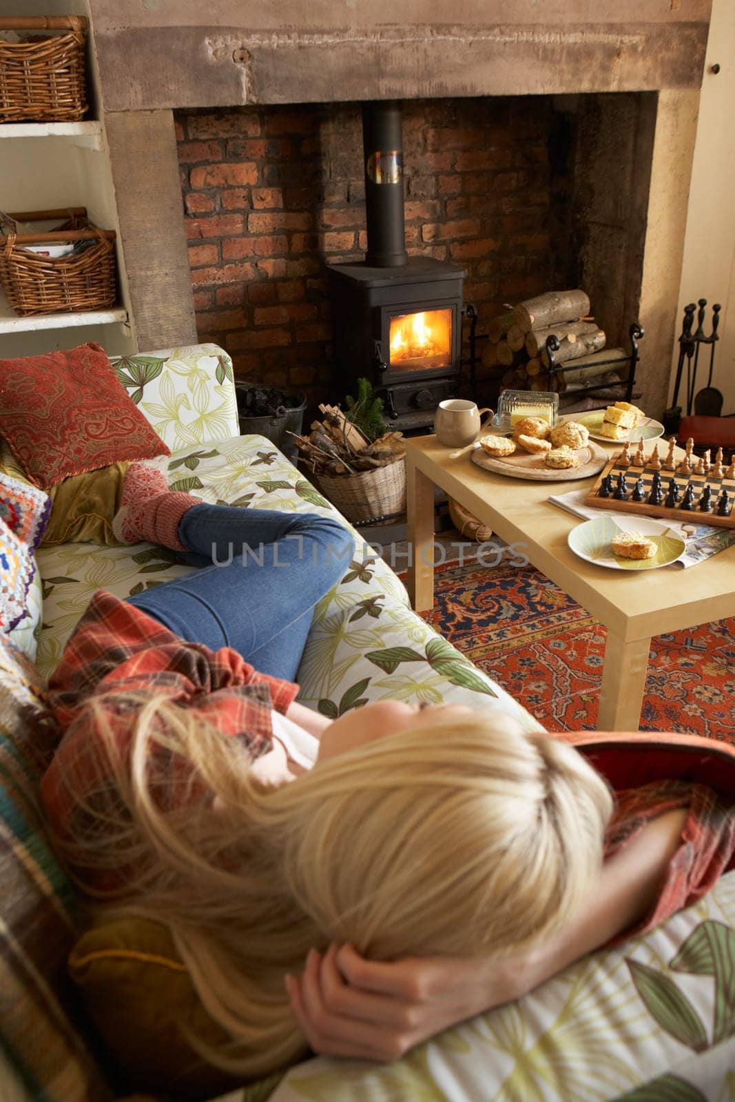 Young woman relaxing by fire