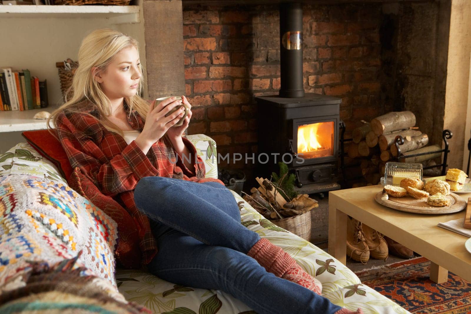 Young woman relaxing by fire