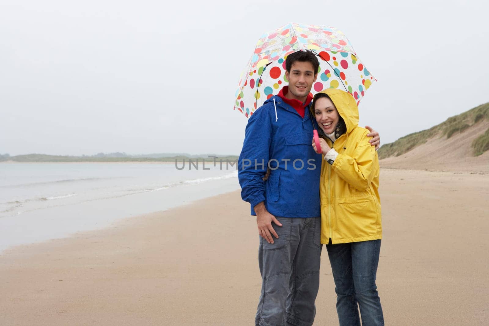 Young couple on beach with umbrella