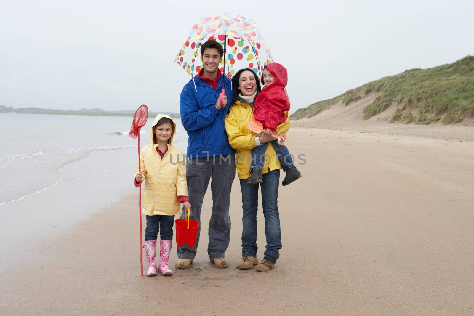 Happy family on beach with umbrella