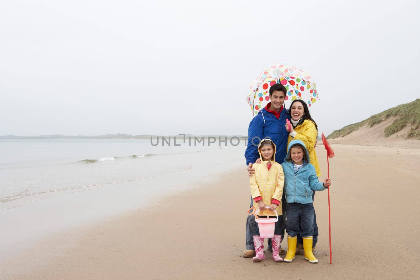 Happy family on beach with umbrella