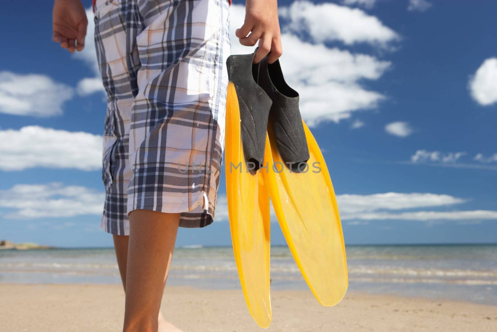 Teenage boy on beach with flippers
