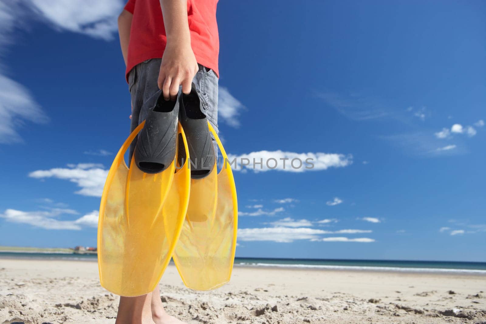 Teenage boy on beach with flippers