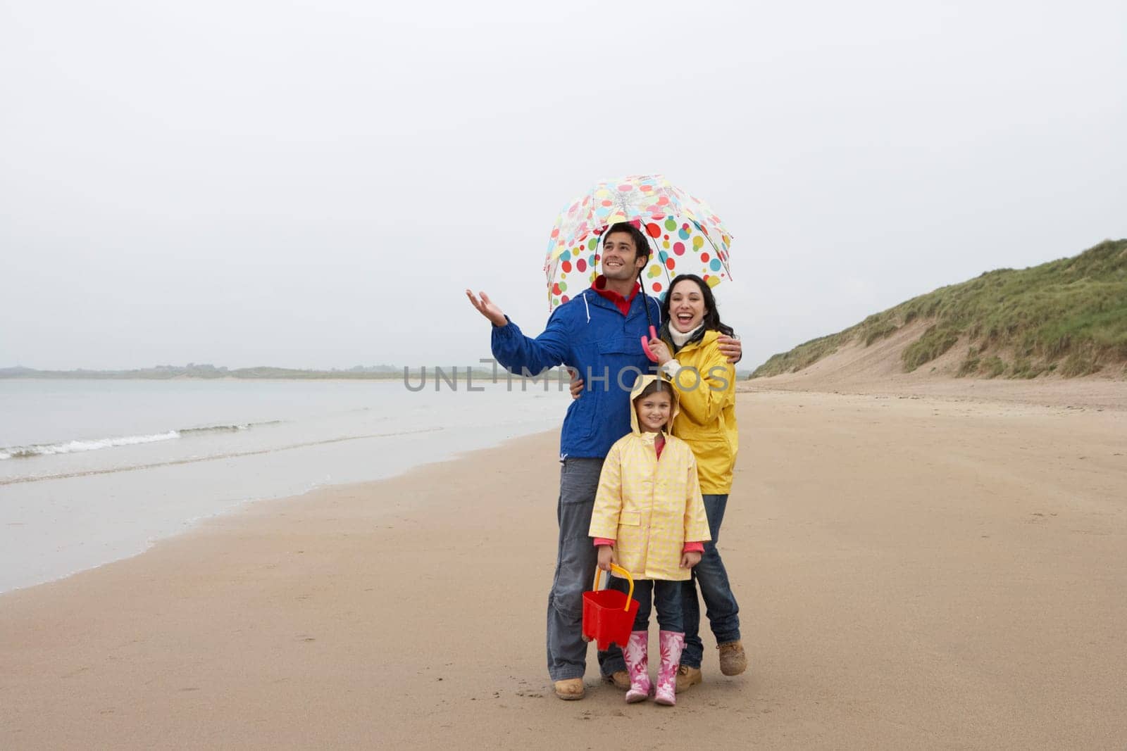 Happy family on beach with umbrella