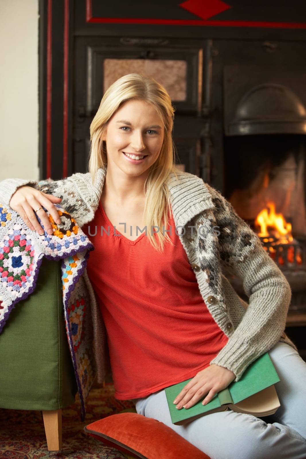 Young woman sitting by open fire