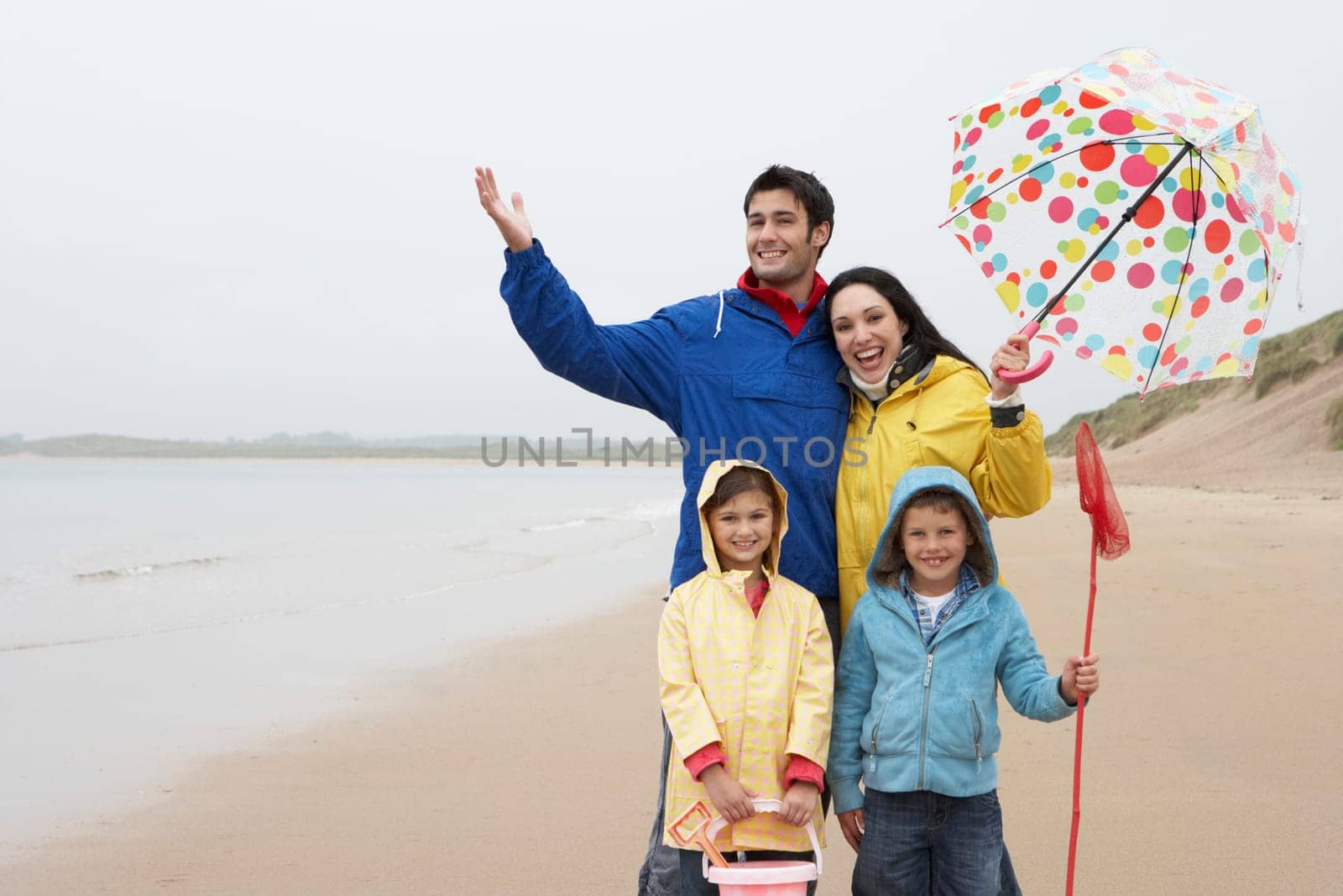 Happy family on beach with umbrella